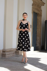 a lady in a black spaghetti strap dress with white polka dots